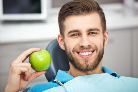 61395463 - my smile is perfect! portrait of happy patient in dental chair with green apple.